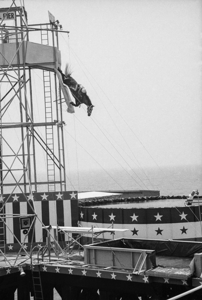 A rider and horse leap from a platform into a pool of water as part of a boardwalk show, Atlantic City, New Jersey, 1969. (Photo by Tim Boxer/Getty Images)