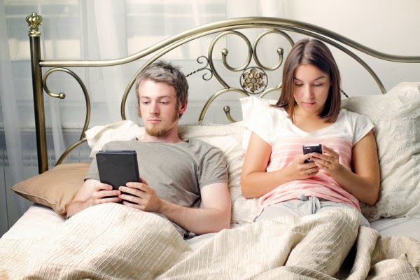 wpid-couple-in-bed-with-phones-600x400