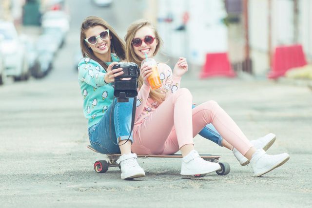 Hipster girlfriends taking a selfie in urban city context - Conc