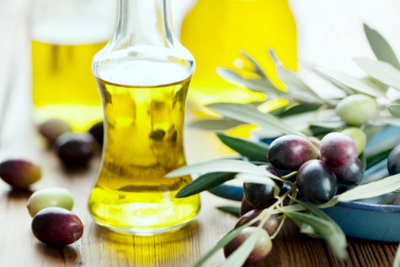 Бутылка с оливковым маслом и ветка оливы