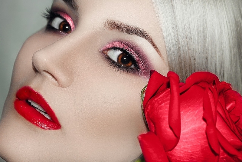 Девушка с ярким макияжем и красной розой