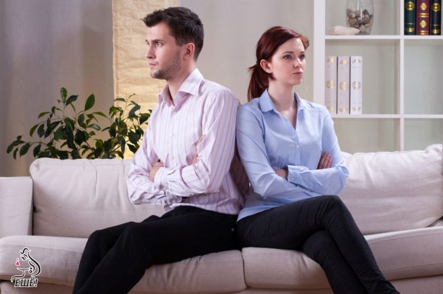 недовольные мужчина и женщина сидят на диване