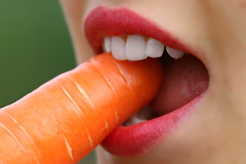 Девушка грызет морковку