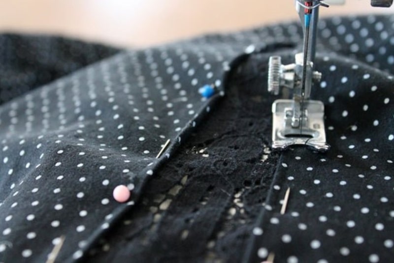 Швейная машинка на ткани с булавками