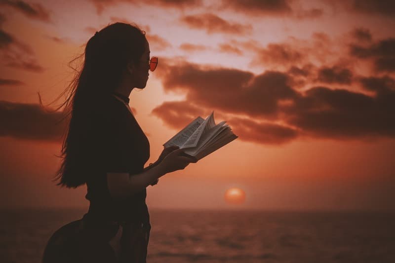 Девушка читает книгу на закате