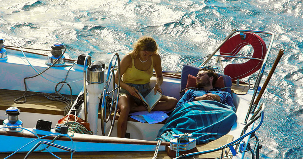 сидящая девушка читает книгу парне на яхте он лежит