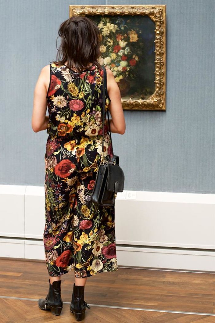 девушка в платье с цветами смотрит на картину