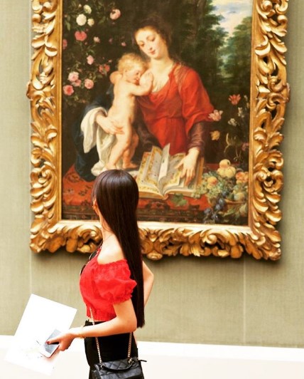 девушка в красном смотрит на картину девушки в красном с ребенком