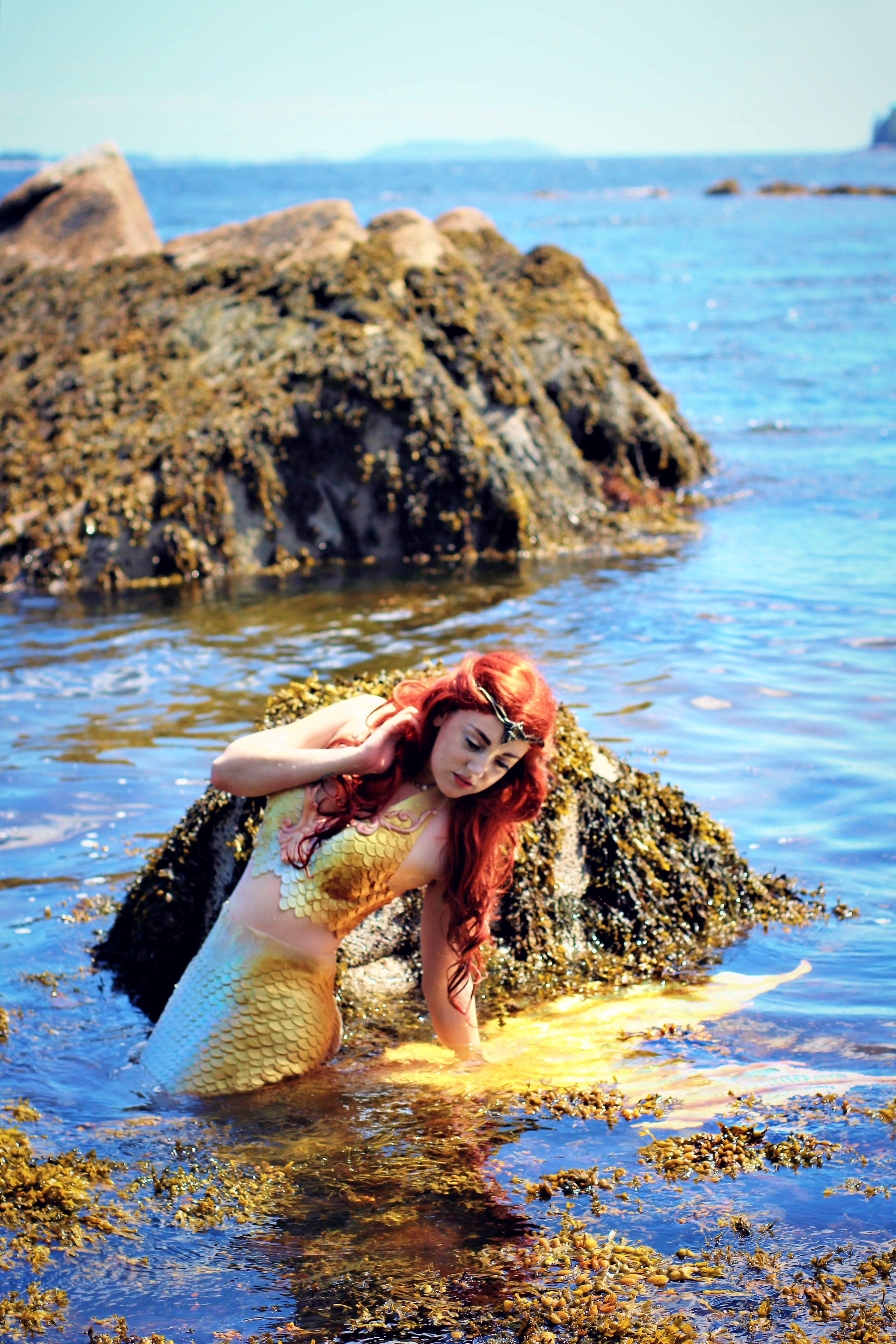девушка-русалка в море возле камней
