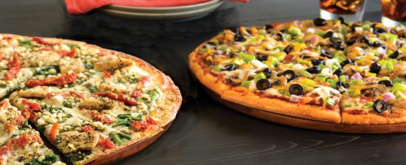 две овощные пиццы на сером столе