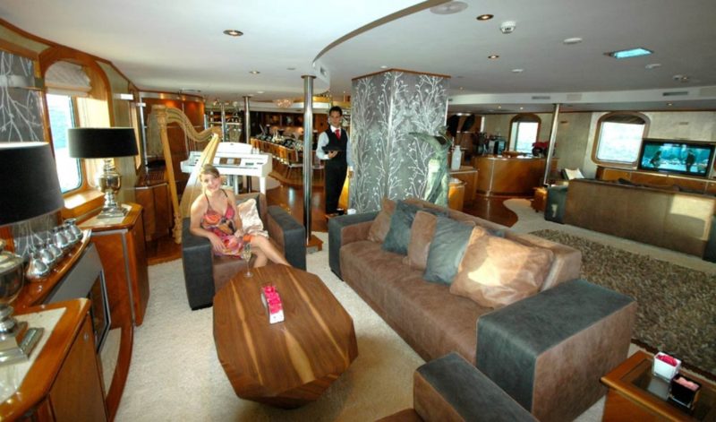 салон яхты с барной стойкой, мягкой мебелью и работающим телевизором