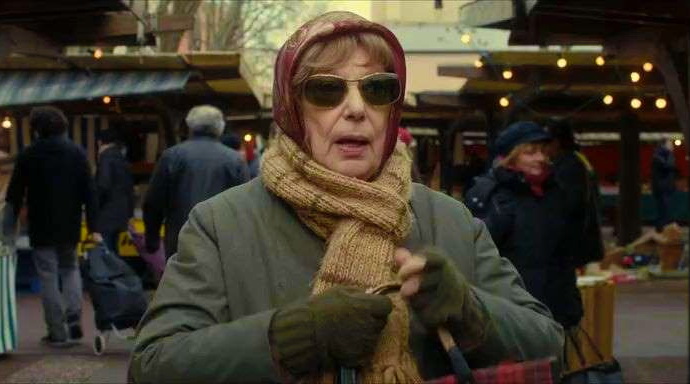 бабушка в темных очках идет по базару