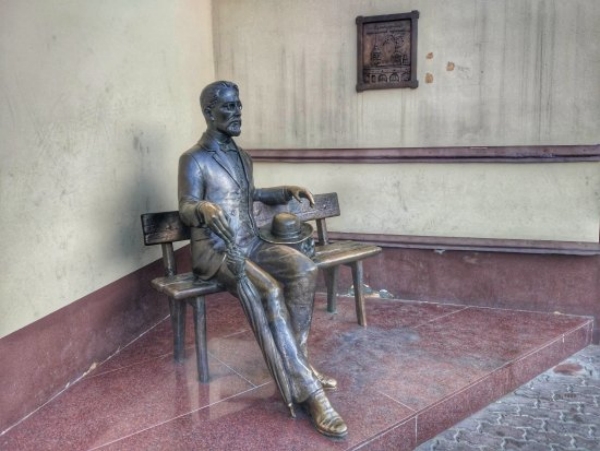 бронзовый памятник Чехову в Ницце - поэт сидит на лавочке с тростью и шляпой в руках