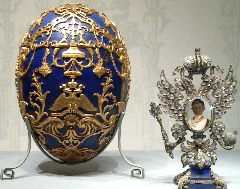яйцо Фаберже “Царевич” синего цвета в золотой клетке с стоящим рядом сюрпризом в виде портрета цесаревича в бриллиантовой рамке