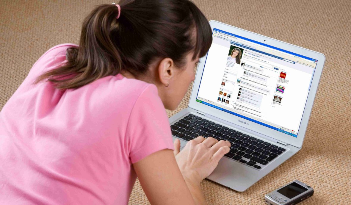 Девушка сидит в соцсетях в ноутбуке