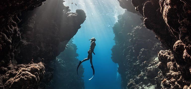 девушка под водой среди пещер