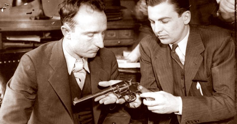 два мужика рассматривают револьвер