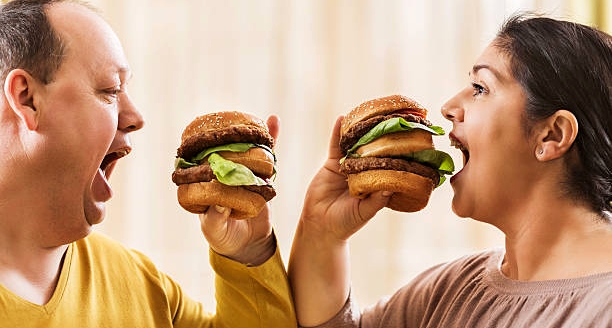 два человека едят гамбургеры