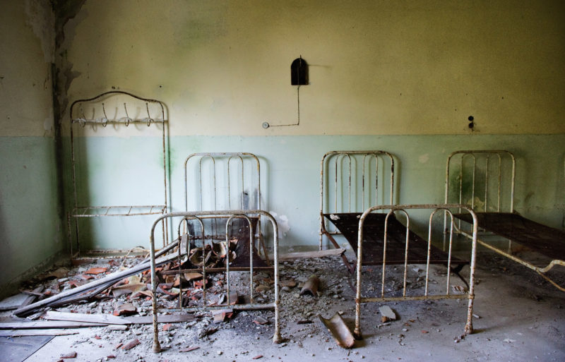 Кровати в заброшенной психиатрической клинике Повельи