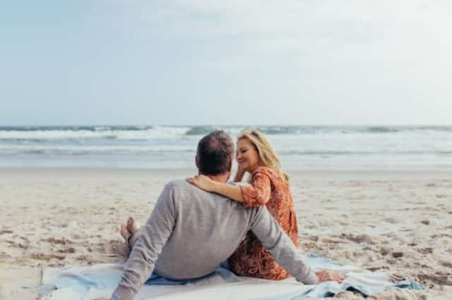зрелая пара обнимается на берегу моря
