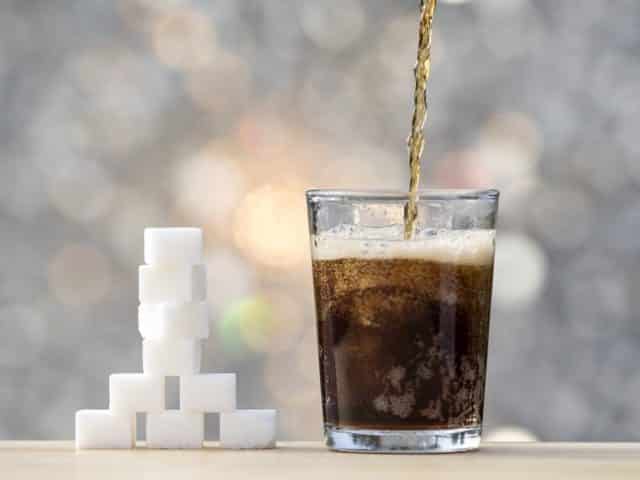 стакан кока-колы и кусочки сахара