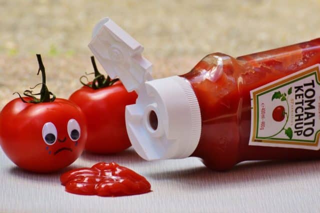 открытая бутылка кетчупа лежит на столе