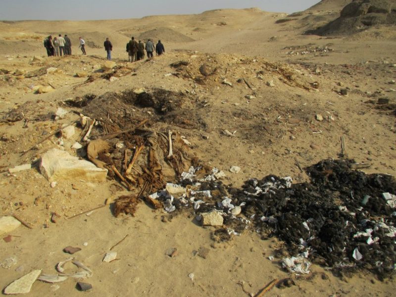груда мусора и группа людей в пустыне