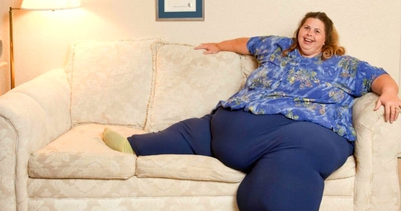 очень толстая (даже жирная, пожалуй) женщина в синих маскировочных штанах на диване
