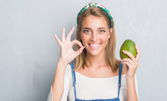 девушка держит манго в руке