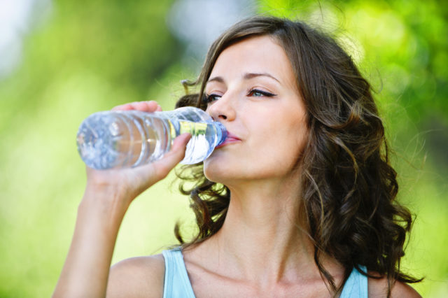 девушка пьет воду из бутылки