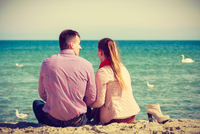 пара сидит на берегу моря
