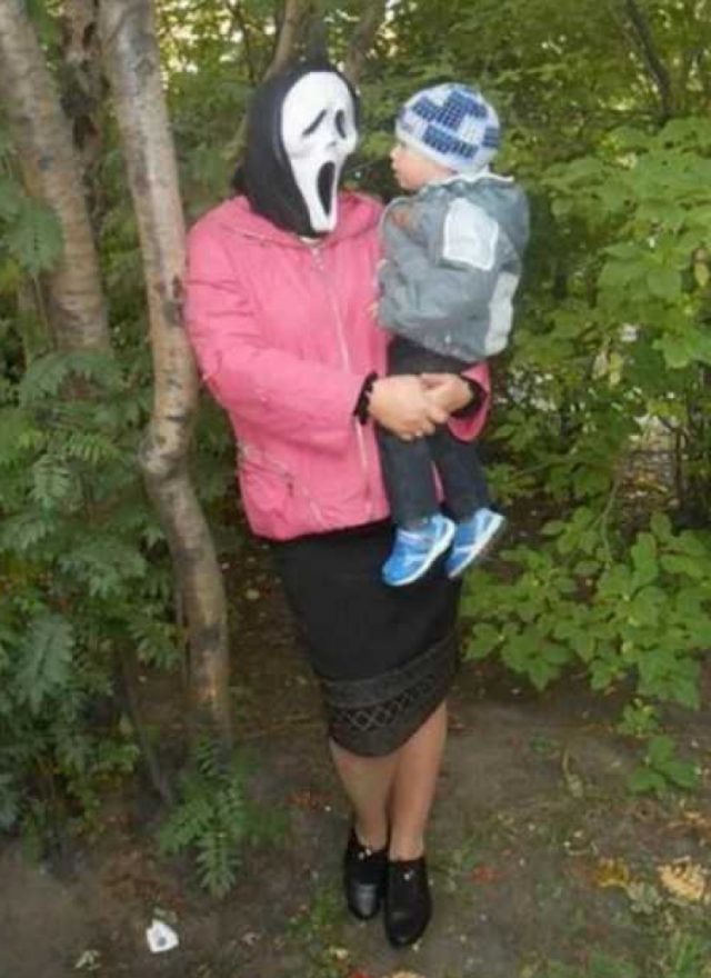 женщина в маске крика с ребенком на руках