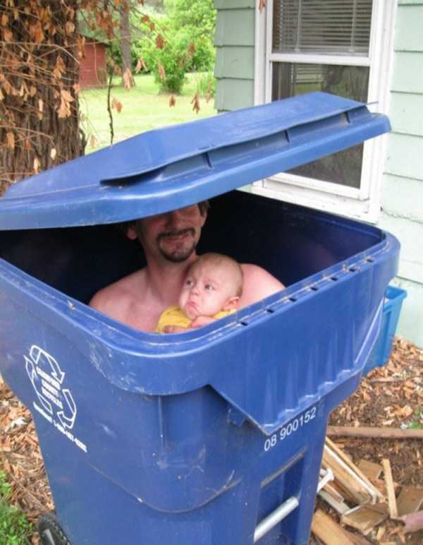 мужчина с ребенком сидит в мусорном баке