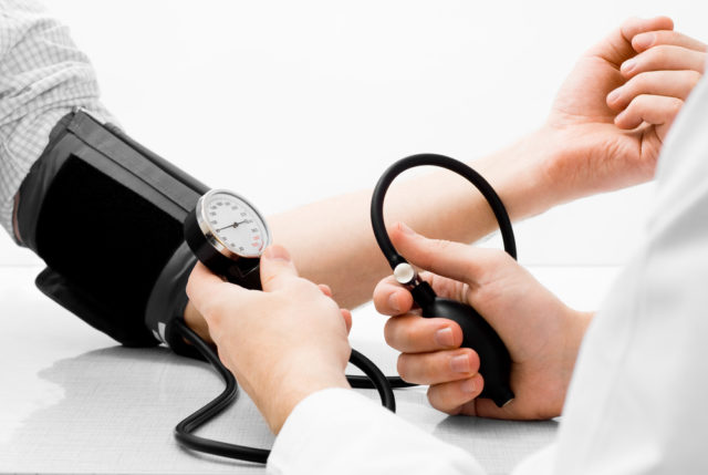 врач измеряет артериальное давление