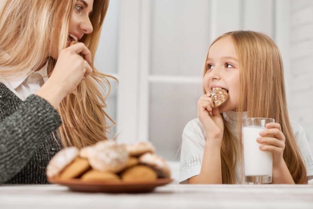 девушка и девочка едят печенье