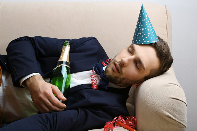 парень спит на диване с бутылкой шампанского