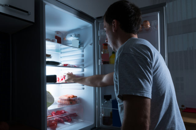 парень у открытого холодильника