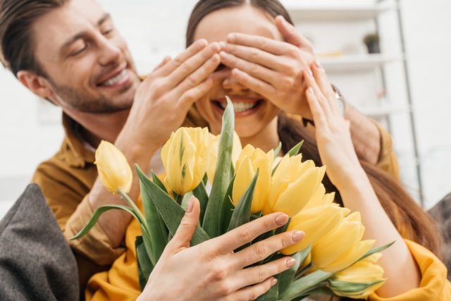 парень дарит девушке желтые тюльпаны