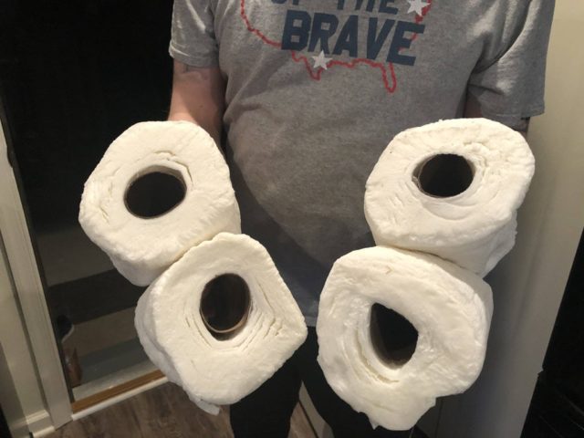 парень держит 4 рулона туалетной бумаги