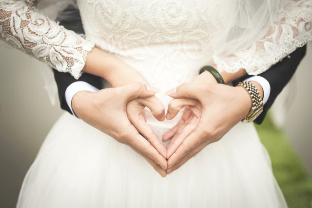 жених и невеста сложили руки в форме сердца