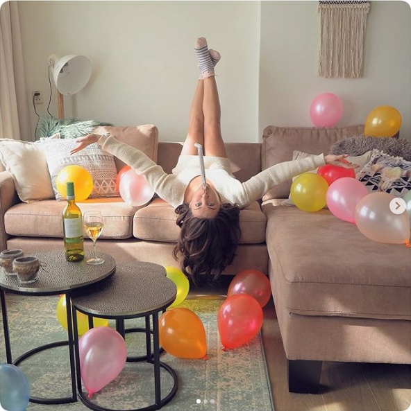 девушка лежит на диване с воздушными шарами вокруг