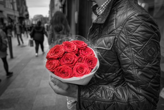 мужчина с букетом красных роз