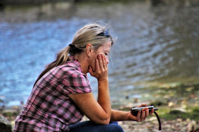 женщина сидит на берегу озера
