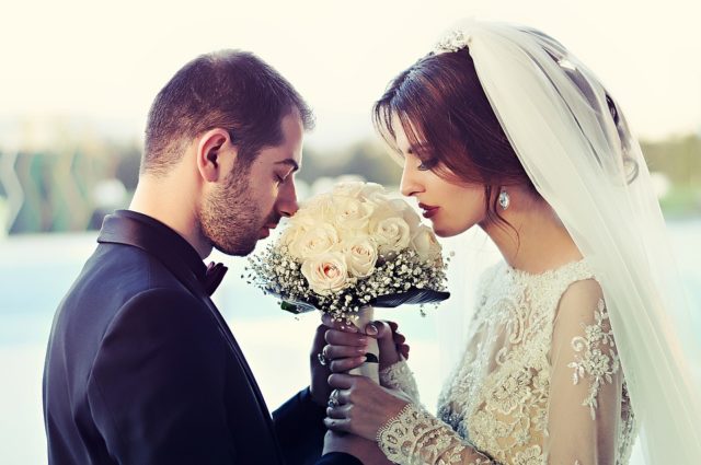 жених и невеста нюхают свадебный букет