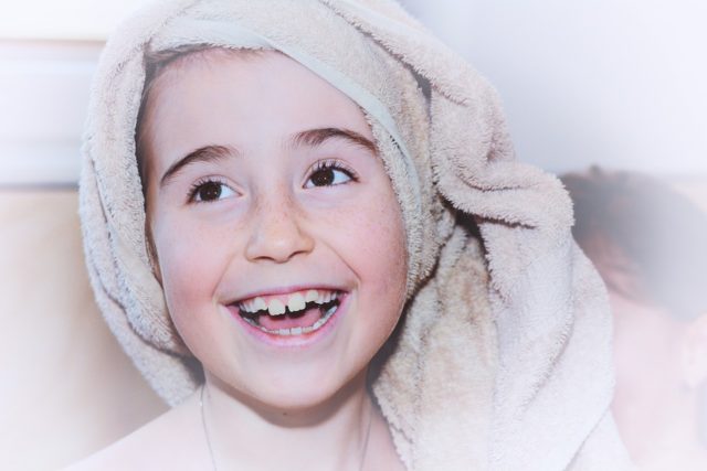 девочка улыбается с полотенцем на голове