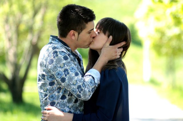 молодая пара целуется в парке
