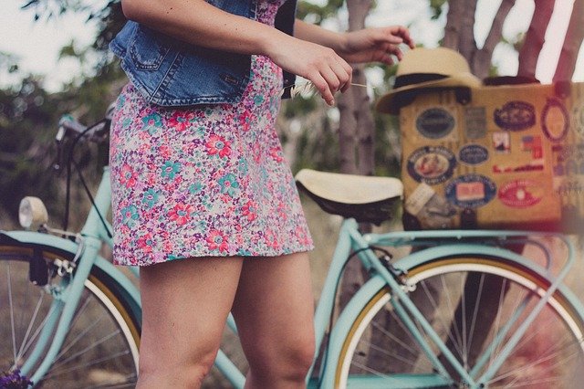 девушка стоит рядом с велосипедом