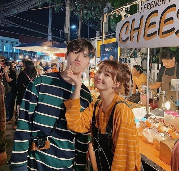 молодая корейская пара в полосатых футболках