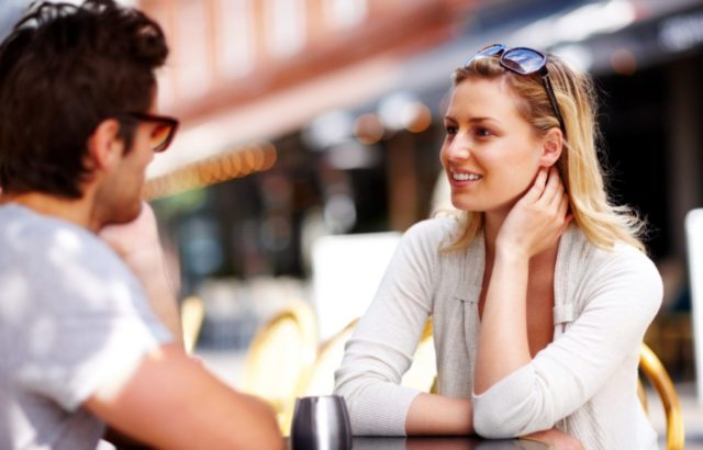 парень и девушка общаются за столиком на улице
