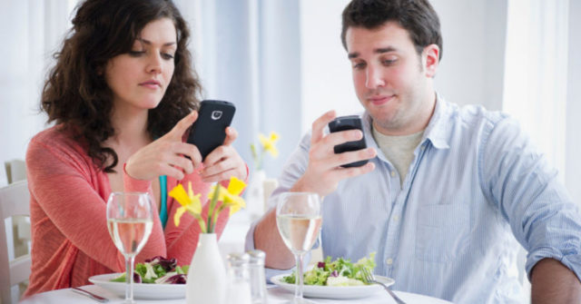 мужчина и женщина с телефоном в руках в ресторане